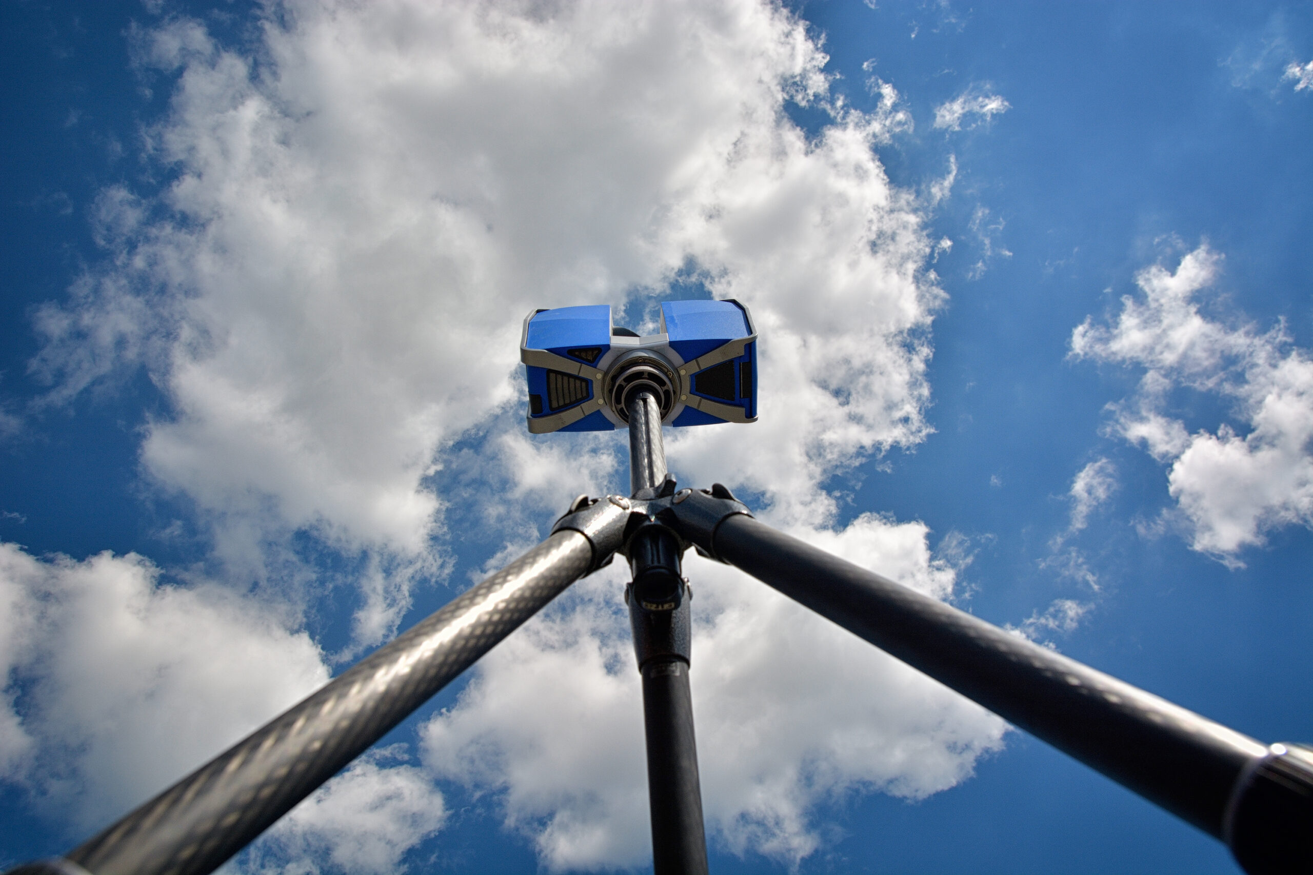 portable 3d laser scanner at tripod on blue skye with clouds